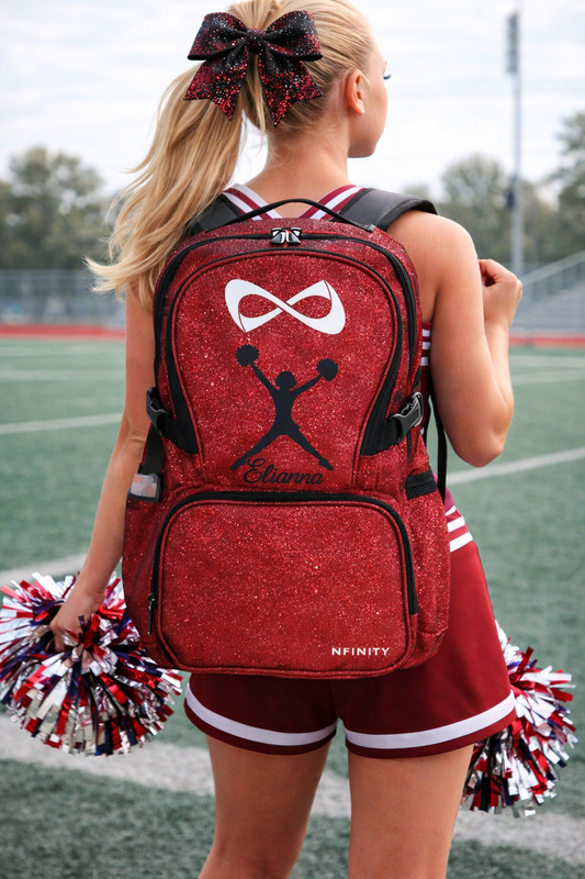 Personalized red glitter cheer backpack with name Elianna and black cheerleader silhouette design on Nfinity bag worn by cheerleader on field