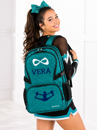 Teen cheerleader wearing a personalized teal Nfinity sparkle backpack embroidered with the name Vera.